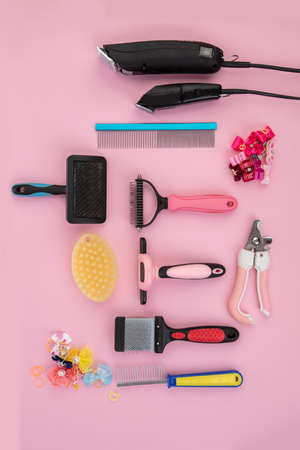 Tool for the groomer on a pink background. dog grooming accessories. Combs and brushes for animals....