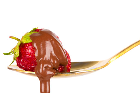 Strawberries on golden spoon with chocolate dipping isolated on white. Chocolate dripping from strawberries. beautiful redberry. sweet dessert.の写真素材