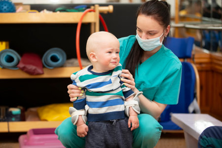 Belarus, the city of Gomi on May 31, 2021. At the Children's Clinic. Physiotherapist is working with a small child.のeditorial素材