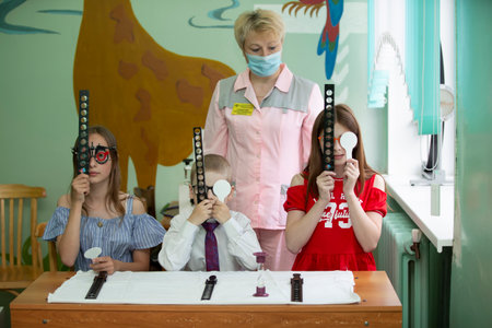 Belarus, city of Gomil, May 31, 2021. Children's health center. A doctor with special eye equipment corrects vision problems in children.のeditorial素材