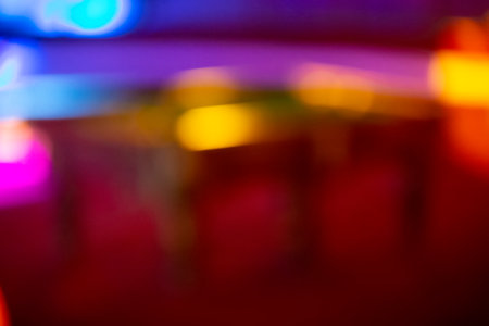 Blurred multicolored background with spots of yellow and purple bokeh. Red background with stripes similar to a night city.の写真素材