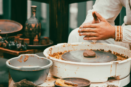 Piece of natural terracotta clay in hands. Wet clay material for sculpture or modeling.の写真素材