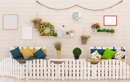 Rustic interior with wooden wall and sofas. Decorated farmhouse style. Background wall with shelves with flowers and furniture. The photo zone is a cozy corner of the house.の写真素材
