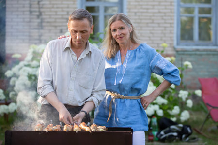 An elderly couple, a man and a woman, are preparing a barbecue.の写真素材