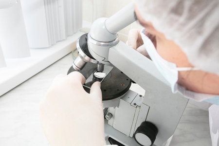 A laboratory assistant looks into a medical microscope. Research analysis.の写真素材