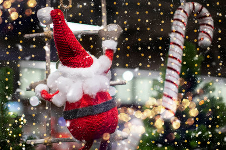 On a Christmas background, a toy santa claus climbs a rope ladder against a background of golden bokeh.の写真素材