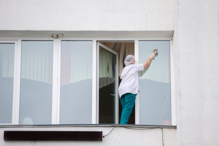 A nurse in a hospital or clinic washes windows. A cleaner in a medical facility.の写真素材