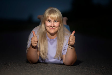 A beautiful plump middle aged woman smiles and shows a class sign with her fingers.の写真素材