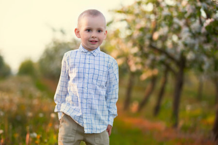 A happy child in a blooming spring garden rejoices, smiles.の写真素材