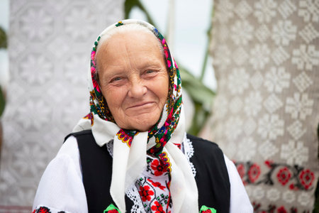 An old Belarusian or Ukrainian woman in an embroidered shirt. Slavic elderly woman in national ethnic clothes.の写真素材