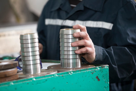 Turning shop or production. Worker's hands hold a metal product coupling.の写真素材