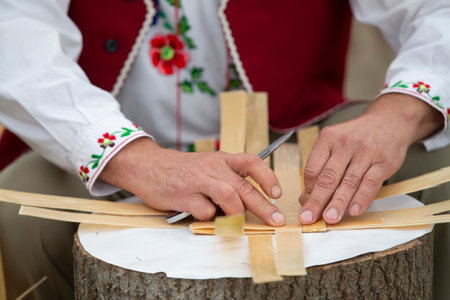 Hands of the master make products from birch bark. Weaving a basket. Ethnic Slavic crafts.の写真素材