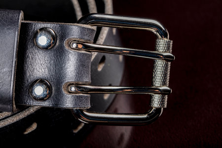 Black leather belt on a dark background. Leather products.