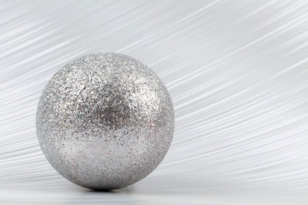 Bright festive background. A sparkling ball on a silver background.の写真素材