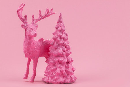 Festive Christmas background. On a pink background, a deer and a Christmas tree.の写真素材