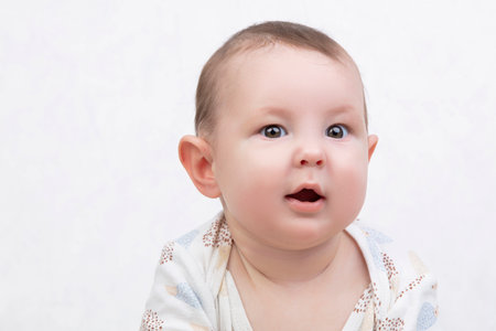 Six month old baby on a white background. Happy boy mid-range. Conceptual photo of fatherhood and motherhood.Alpha generation.の写真素材