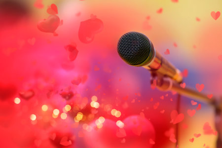 Stage golden microphone on the background of red valentine hearts and golden bokeh.の写真素材