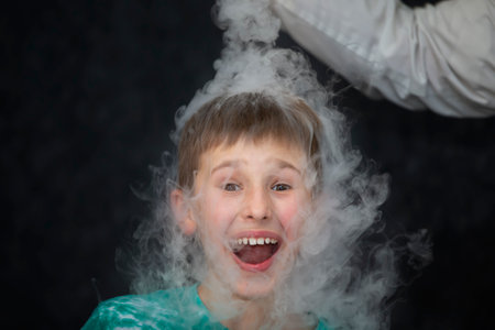 The child is a participant in scientific experiments. A boy in liquid nitrogen smoke.の写真素材