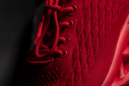 Part of a red fabric sneaker on a black background close-up. Textile shoes.の写真素材