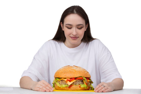 A woman is holding a big barbecue hamburger sandwich on the background. Fast food concept. The girl has a huge hamburger.の写真素材