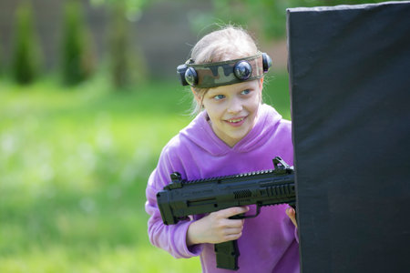 Belarus, Yagodnaya village, May 27, 2021. Children's holiday. A girl with a laser weapon plays laser tag.のeditorial素材