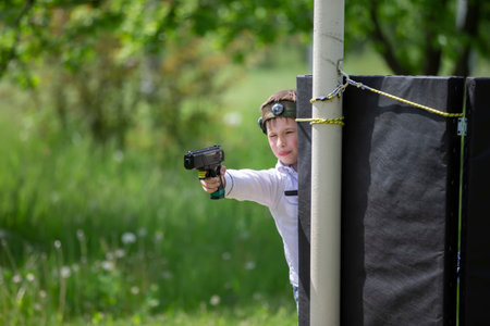 Belarus, Yagodnaya village, May 27, 2021. Children's holiday. A boy with a laser weapon plays laser tag.のeditorial素材