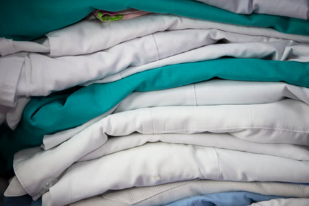 White and green medical gowns are stacked.の写真素材