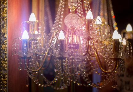 Part of an antique luxury pendant lamp with sparkling beads illuminated by light.