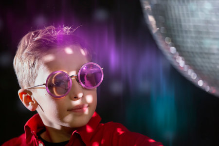 Handsome young boy in stylish glasses in dark neon lighting.の写真素材
