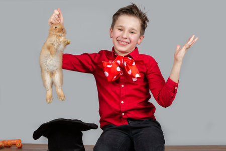 The magician boy takes out the rabbit from the cap.の写真素材