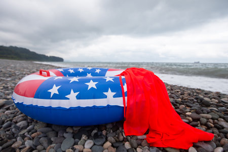 A lifebuoy with an American flag painted on the seashore. Vacation vacation on American beaches.の写真素材