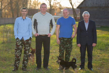 October 22, 2021. A group of elderly village men of varying heights and builds pose for the camera....