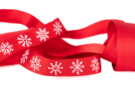 Christmas red ribbon with white snowflakes isolated.の写真素材