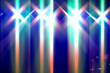 Bright festive multi-colored stage lighting with optical flare and rays from lighting lamps.の写真素材