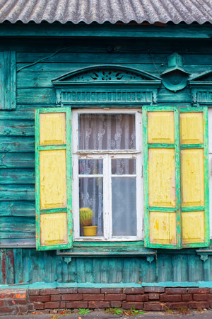 Background of an old window with wooden shutters. Wall of a wooden house with a window.の写真素材