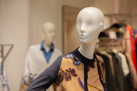 Female mannequin in floral clothing in a store window.