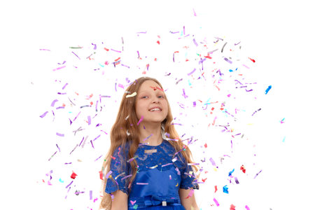 Little happy girl throwing colorful confetti on a white background.の写真素材
