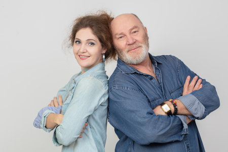 Portrait of an adult daughter with her father on a gray background.の写真素材