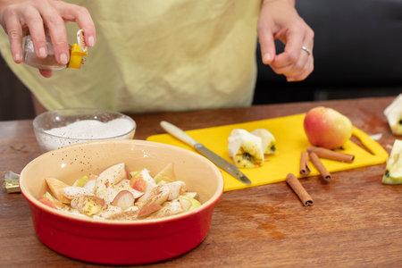 Hands sprinkle cinnamon on apples. Cooking apple pie.の写真素材