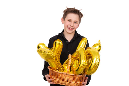 A teenage boy holds golden letter balloons for the holiday. A child celebrates his birthday on a white background.の写真素材