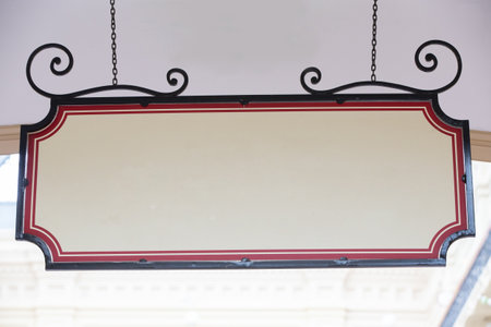 Blank curly rectangular banner sign hanging on chain blank template.の写真素材