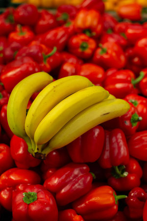 A branch of ripe bananas and peppers on the shop window.の写真素材
