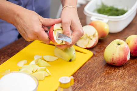 Hands cutting apples with a knife. Prepare healthy food from fruits.の写真素材