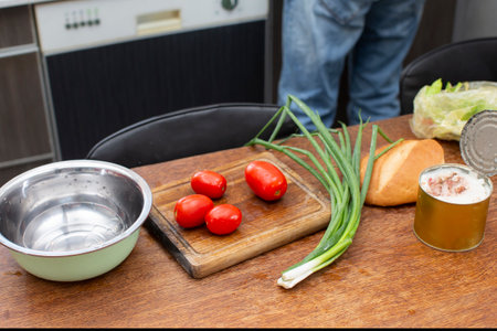 Chop the green onions and tomatoes and place them in a bowl. Prepare the salad.の写真素材