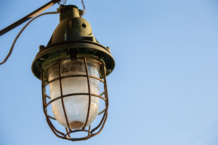Vintage retro street lamp on a blue sky background.の写真素材