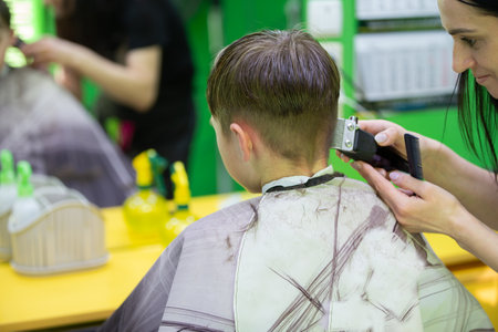 The boy gets a haircut at the barbershop. They do a short hairstyle.の写真素材