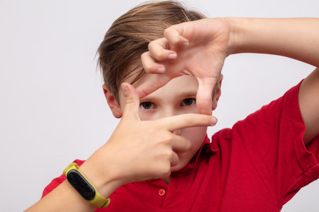 A teenage boy shows the camera with his fingers or a shooting gesture.