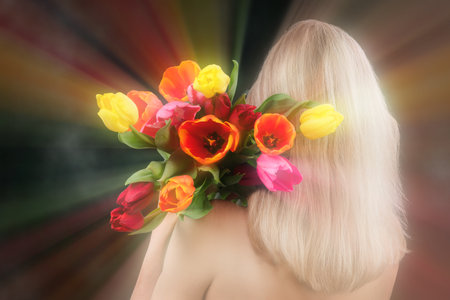 Behind the blonde's back is a bouquet of flowers on a blurred background of optical smoke rays. Conceptual women's beauty and health.の写真素材