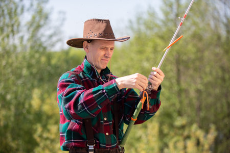 An adult man with a fishing rod while fishing.