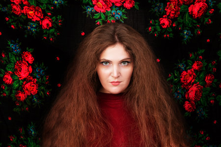 Portrait of a woman with long hair with a piercing gaze in a floral background. The mystical girl is mysterious.の写真素材